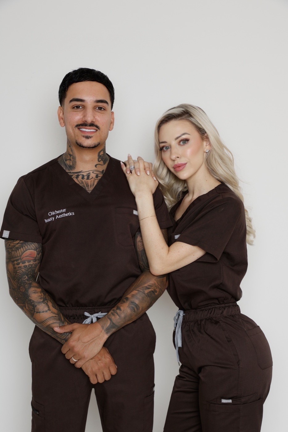 Tanisha and Michael, founders of The Beauty Aesthetics Group, in clinic scrubs