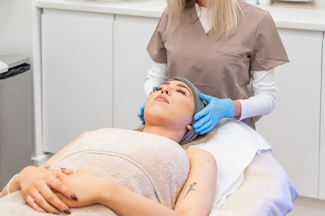A practitioner preparing a client for a facial treatment